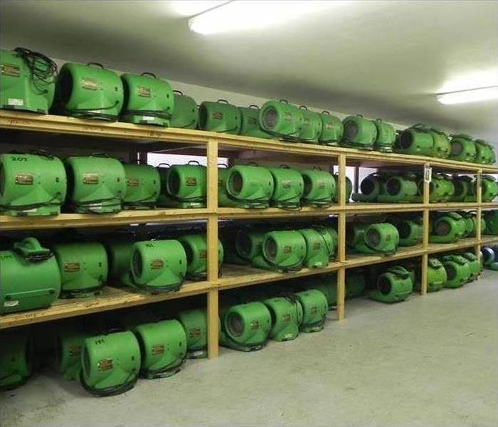 Air movers sitting on a shelf in a warehouse